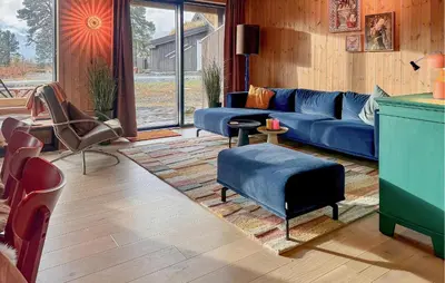 a living room with a blue couch and chairs at Cozy Home In Rauland With Sauna in Torvetjørn