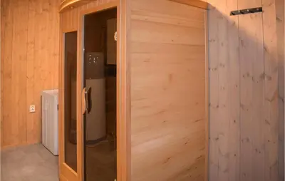 a wooden door in a room with a refrigerator at Cozy Home In Rauland With Sauna in Torvetjørn