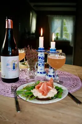 a table with a bottle of wine and a plate of food at The Olav-house from 1840, at farm Ellingbø in Vang I Valdres