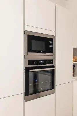 a microwave oven in a white kitchen at Dinbnb Apartments I Luxury with Views l Large Balcony in Bergen