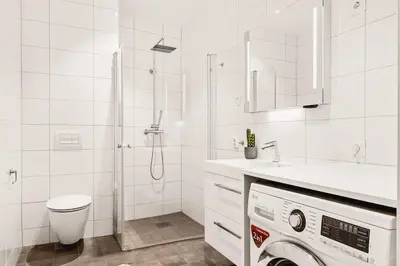 a white bathroom with a washing machine in it at Dinbnb Apartments I Luxury with Views l Large Balcony in Bergen