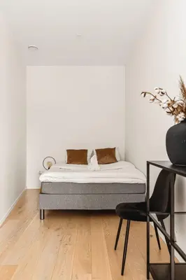 a white room with a bed and a chair at Dinbnb Apartments I Luxury with Views l Large Balcony in Bergen