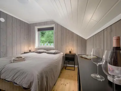 a bedroom with a bed and a desk and a window at Holiday Home Mathias by Interhome in Vik