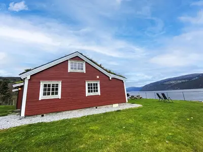 a red house on the shore of a lake at Chalet Krampehaugen by Interhome in Utvik