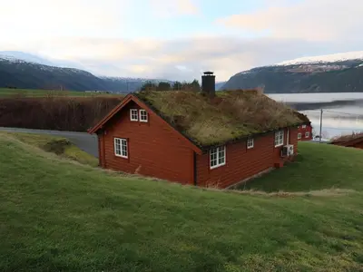 a red house with a grass roof on a hill at Chalet Hagehytta by Interhome in Utvik