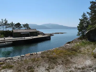 a building on a dock next to a body of water at Holiday Home Sognesjö by Interhome in Bø