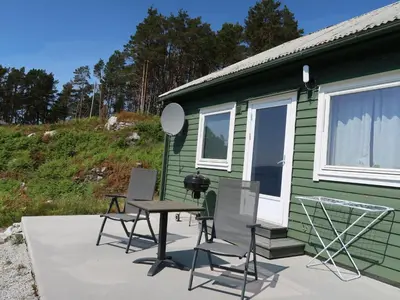 a table and chairs on a patio next to a green house at Holiday Home Sognesjö by Interhome in Bø