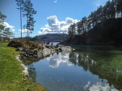a body of water with trees and clouds in the sky at Apartment Heningen by Interhome in Uggdal