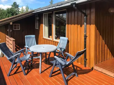 a table and chairs on the deck of a cabin at Chalet Trefall by Interhome in Gausvik