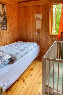 a bedroom with a bed in a wooden room at Chalet Trefall by Interhome in Gausvik