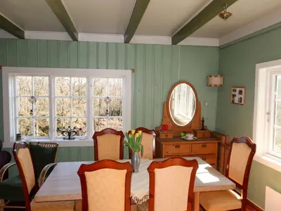 a dining room with a table and a mirror at Holiday Home Sjøhytta by Interhome in Bekkjarvik