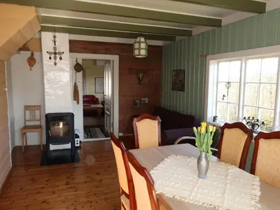 a living room with a table and a fireplace at Holiday Home Sjøhytta by Interhome in Bekkjarvik
