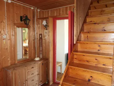 a wooden staircase in a room with a red door at Holiday Home Sjøhytta by Interhome in Bekkjarvik