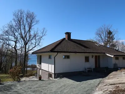 a white house with a roof on a driveway at Holiday Home Villa Hjartnes by Interhome in Hjartåker