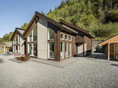 a house with a lot of windows on a gravel driveway at Holiday Home Kaja by Interhome in Vik