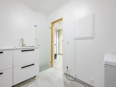 a white kitchen with white cabinets and a sink at Holiday Home Kaja by Interhome in Vik