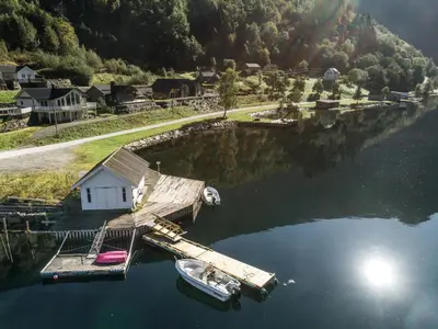 a small dock with a boat in the water at Holiday Home Kaja by Interhome in Vik
