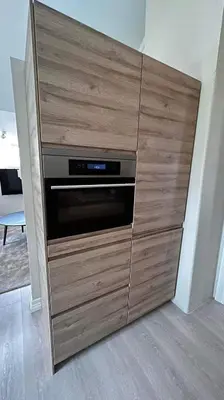 a large wooden cabinet with an oven in a room at Bo i historisk bygning, kort vei til sentrum in Trondheim