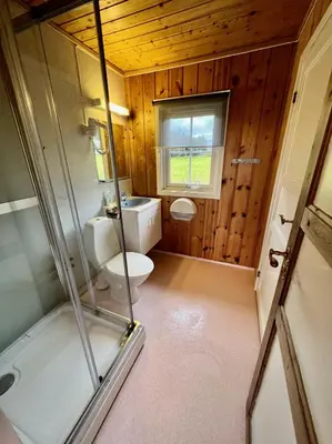 a bathroom with a toilet and a glass shower at Gullvåg Camping Nyberg in Soknedal