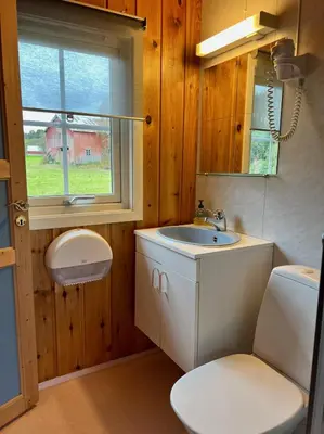 a bathroom with a sink and a toilet and a window at Gullvåg Camping Nyberg in Soknedal
