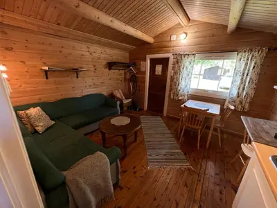 a living room with a green couch and a table at Gullvåg Camping Nyberg in Soknedal
