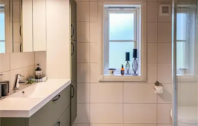 a bathroom with a sink and a window at Nice Home In Sykkylven With Kitchen in Sykkylven