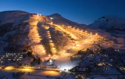 a snow covered mountain with lights on it at night at Nice Home In Straumgjerde in Riksem