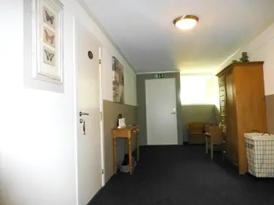 a room with a hallway with a door and a table at Løvheim Gjestehus in Sauland