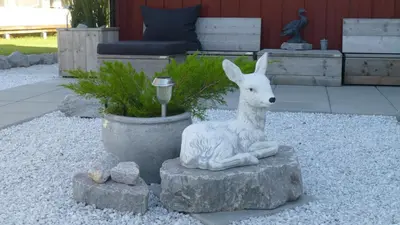 a statue of a deer sitting on a rock at Løvheim Gjestehus in Sauland