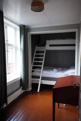 a bedroom with a bunk bed and a staircase at Skanckegårdene AS in Røros