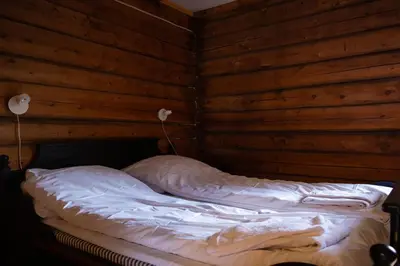 a bed in a room with a wooden wall at Skanckegårdene AS in Røros