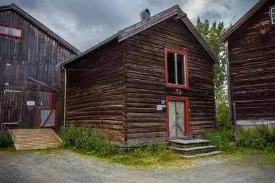 an old wooden building with a red door and a barn at Skanckegårdene AS in Røros
