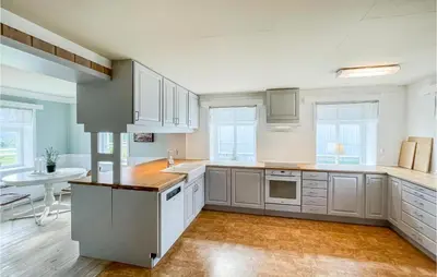 a large kitchen with white cabinets and a table at Lovely Home In Koppang With Kitchen in Koppang
