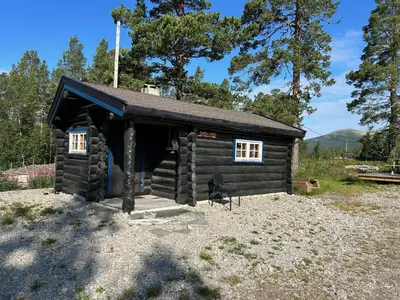 a small log cabin with two windows on it at Atnasjø Kafe AS in Sollia