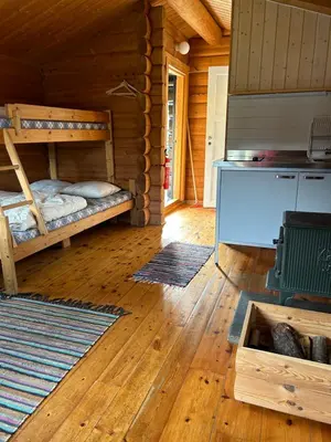 a room with two bunk beds in a log cabin at Atnasjø Kafe AS in Sollia