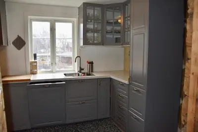 a kitchen with gray cabinets and a sink and a window at Nedre Stensgården in Røros