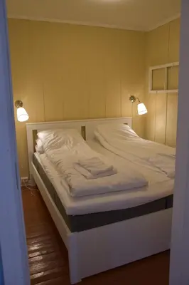 a bed in a room with two lights on it at Nedre Stensgården in Røros