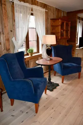 a living room with two blue chairs and a table at Nedre Stensgården in Røros