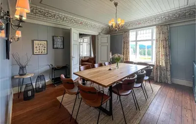 a dining room with a wooden table and chairs at Gorgeous Home In Koppang With Sauna in Koppang