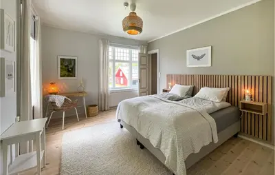 a bedroom with a bed and a chair and a window at Gorgeous Home In Koppang With Sauna in Koppang