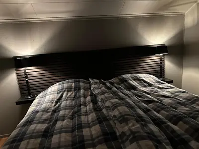 a bed with a plaid blanket and two lamps at Hemsedal 200m2 /5 sov/10 senger/2 familier in Torset