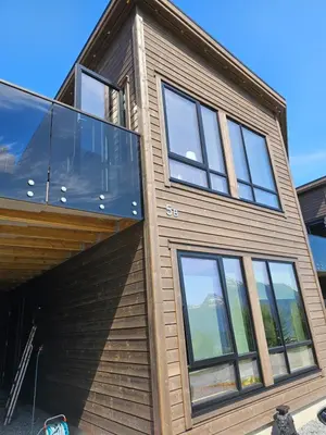 a house with glass windows on the side of it at Panorama view in Stranda