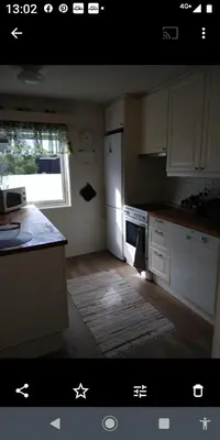 a kitchen with a white refrigerator and a window at Nardo-Trondheim in Trondheim