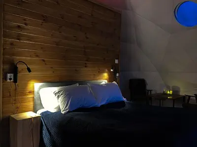 a bedroom with a bed with a wooden wall at Olden Glamping - One with nature in Stryn