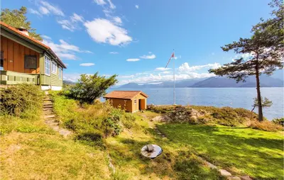 a house on a hill next to a body of water at Amazing Home In Tørvikbygd With Wifi in Tyrvikbygd