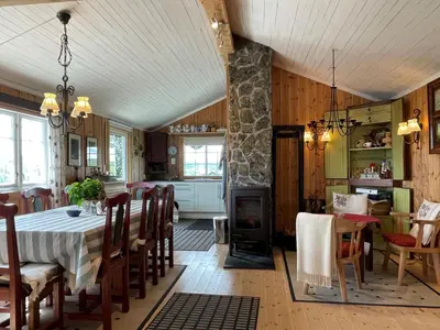 a kitchen and dining room with a table and a fireplace at Snikkerplassen - cabin with amazing view and hiking opportunities in Sør-Fron