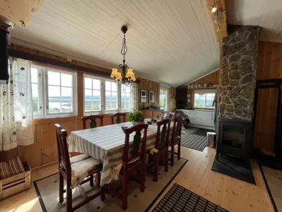 a dining room with a table and chairs and a fireplace at Snikkerplassen - cabin with amazing view and hiking opportunities in Sør-Fron