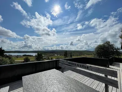 a wooden bench sitting on top of a wooden deck at Snikkerplassen - cabin with amazing view and hiking opportunities in Sør-Fron