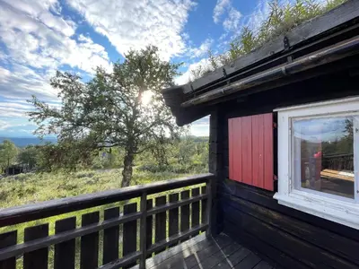 a view from the porch of a cabin with a window at Elveseter - log cabin with an amazing view in Venabygd