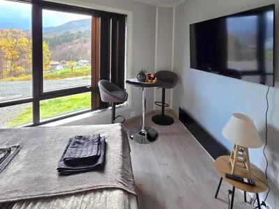 a bedroom with a bed and a large window at Panorama view in Stranda